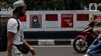 Warga melintasi mural sosialisasi bahaya COVID-19 di Jalan Sultan Iskandar Muda, Jakarta, Rabu (23/9/2020). PSBB pengetatan sepekan terakhir ini belum efektif menurunkan angka jumlah harian Covid-19 di DKI yang tercatat bertambah 1.122 kasus di ibu kota pada Selasa (22/9). (Liputan6.com/Johan Tallo)