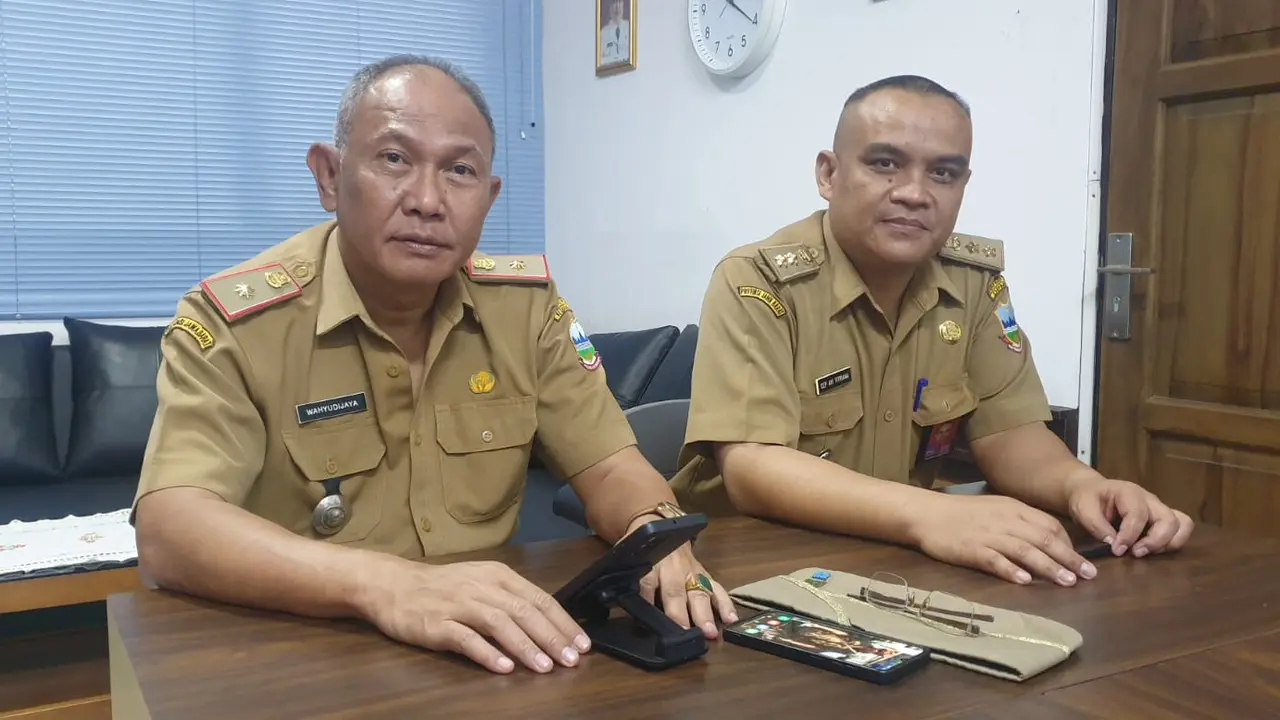 Kepala Dinas Penanaman Modal dan Pelayanan Terpadu Satu Pintu (DPMPTSP) Garut Wahyudijaya bersama Kabid Infrastruktur, di kantornya. (Liputan6.com/Jayadi Supriadin)
