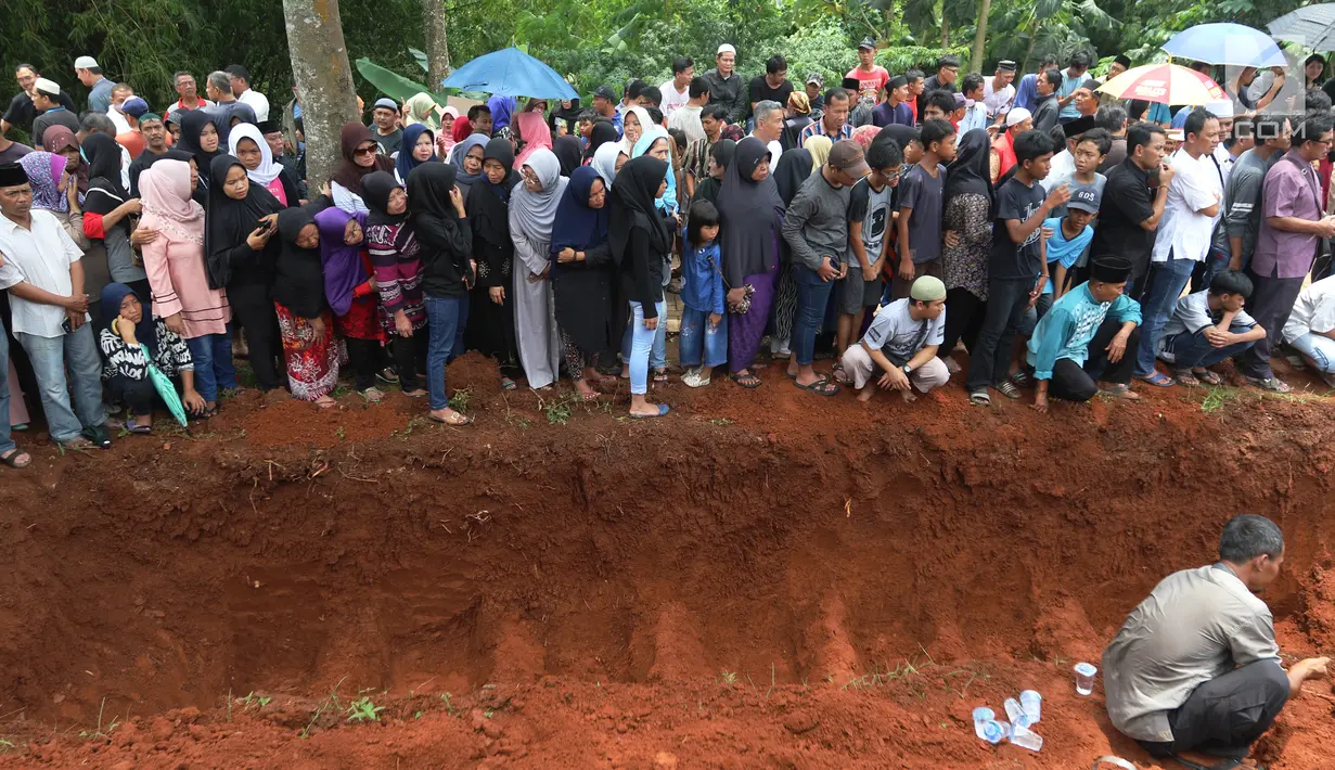 Suasana jelang pemakaman massal korban kecelakaan Tanjakan Emen di Tempat Pemakaman Umum (TPU) Legoso, Tangerang Selatan, Banten, Minggu (11/2). Keluarga dan kerabat nampak memenuhi lokasi pemakaman. (Liputan6.com/JohanTallo)