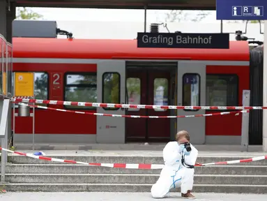 Polisi mengambil gambar di lokasi penyerangan di stasiun kereta komuter S-Bah di Grafing, kota di Munich, Jerman selatan, Selasa (10/5). Penikaman yang dilakukan seorang pria berusia 27 tahun itu dilaporkan menewaskan satu orang. (REUTERS/Michaela Rehle)