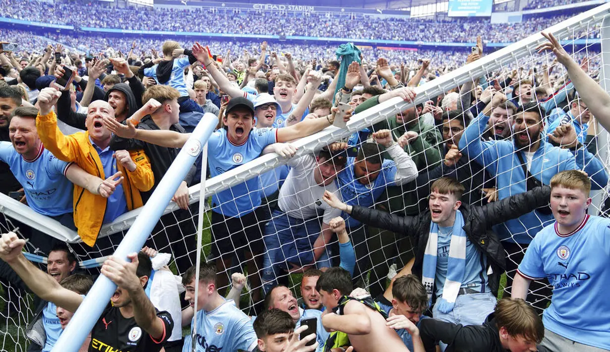 Suporter Manchester City langsung turun ke lapangan usai Manchester City berhasil menaklukkan Aston Villa pada laga pekan terakhir Liga Inggris. (Martin Rickett/PA via AP)