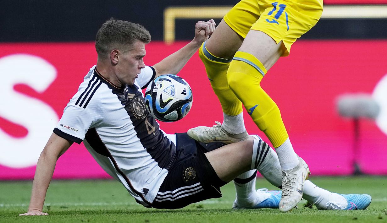 Pemain Timnas Jerman, Matthias Gunter (kiri), berusaha merebut bola dari pemain Ukraina, Artem Dovbyk, dalam laga persahabatan internasional FIFA Matchday 2023 yang digelar di Weserstadion, Bremen, Senin (12/6/2023) malam WIB. (AP Photo/Martin Meissner)