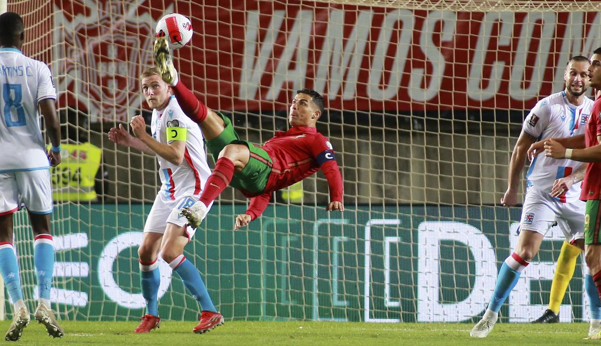 Penyerang Portugal Cristiano Ronaldo (tengah) mencoba mencetak gol dengan tendangan overhead ke gawang Luksemburg pada lanjutan Kualifikasi Piala Dunia 2022 di Stadion Do Algarve, Rabu (13/10/2021) dini hari WIB. Hat-trick Ronaldo membuat Portugal menang 5-0 atas Luksemburg. (AP Photo/Joao Matos)