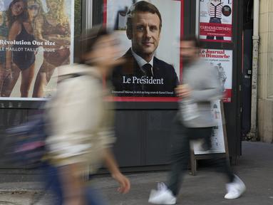 Sebuah potret halaman depan Presiden Emmanuel Macron ditampilkan di sebuah stand berita, di Paris, Prancis, Senin (25/4/2022).&nbsp; Emmanuel Macron akhirnya berhasil memperpanjang masa jabatannya sebagai Presiden Prancis hingga lima tahun ke depan pada hari Minggu, setelah mengalahkan kandidat dari partai sayap kanan Marine Le Pen. (AP Photo/Francois Mori)