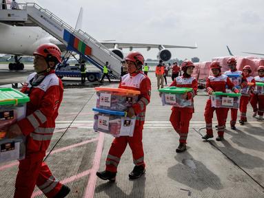 Personel Palang Merah Indonesia (PMI) membawa kotak-kotak berisi bahan bantuan setelah upacara keberangkatan misi bantuan kemanusiaan Indonesia ke Myanmar di Pangkalan Udara Halim Perdanakusuma, Jakarta, 3 April 2025. (YASUYOSHI CHIBA/AFP)