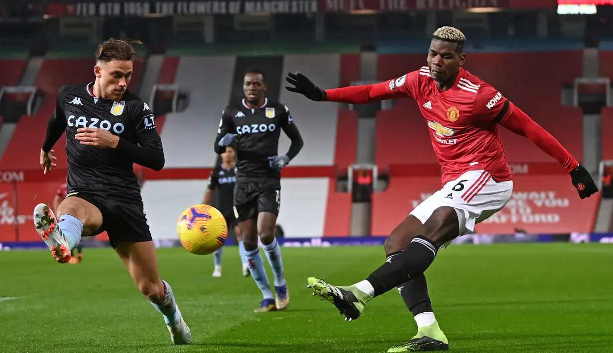 Gelandang Manchester United, Paul Pogba (kanan) melepaskan umpan di depan bek Aston Villa, Matty Cash dalam laga lanjutan Liga Inggris 2020/21 pekan ke-17 di Old Trafford, Jumat (1/1/2021). Manchester United menang 2-1 atas Aston Villa. (AFP/Laurence Griffiths/Pool)