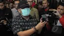 Hasto Kristiyanto menggunakan masker dan topi menunjukkan alat anti sadap telepon genggam saat menggelar konferensi pers di Jakarta, Kamis (22/1/2015). (Liputan6.com/Herman Zakharia)