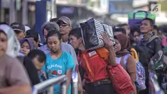 Sejumlah pemudik mengantre di pintu keberangkatan Stasiun Pasar Senen, Jakarta, Selasa (12/6). Sebanyak 25 ribu lebih pemudik berangkat dari Stasiun Pasar Senen dengan tujuan yang paling banyak dituju Semarang dan Surabaya. (Liputan6.com/Faizal Fanani)