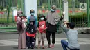 Warga berfoto di depan pagar Monumen Nasional (Monas), Jakarta, Sabtu (15/5/2021). Warga kecewa lantaran tempat wisata tersebut ditutup, padahal mereka datang untuk menikmati libur Idul Fitri 1442 Hijriah. (merdeka.com/Imam Buhori)
