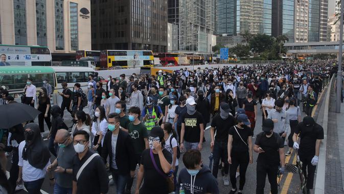 Demonstran berbaris dan memblokir jalan di Distrik Central, Hong Kong, Senin (11/11/2019). Ketegangan di Hong Kong semakin meningkat setelah polisi menembak seorang demonstran hingga kritis. (AP Photo/Kin Cheung)