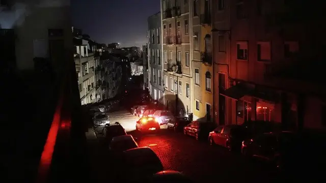 Sebuah mobil melaju di jalan yang gelap di Lisbon, selama pemadaman listrik nasional, Senin (28/4/2025).