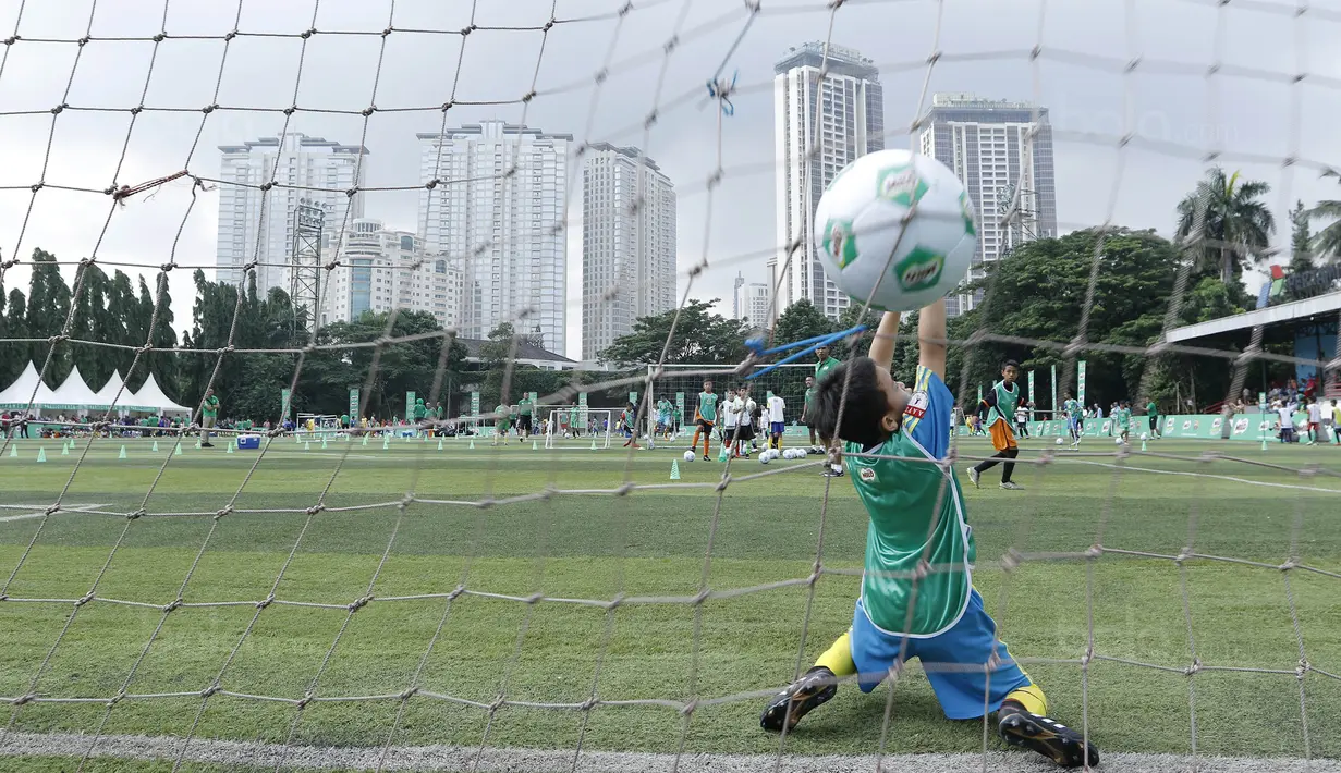 Seorang anak berusaha menangkap bola saat mengikuti MILO Football Clinic Day di Lapangan Simprug, Jakarta, Sabtu (16/12/2017). Sebanyak 500 anak mendapatkan pelatihan dasar teknik sepak bola dari pelatih berpengalaman. (Bola.com/M Iqbal Ichsan)