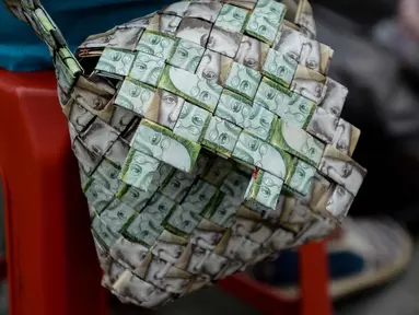 Tampilan tas dari lembaran Bolivar buatan Rojas di Caracas, Venezuela, pada 30 Januari 2018. Inflasi yang tinggi membuat mata uang tersebut terus kehilangan nilainya. (AFP Photo/Federico Parra)