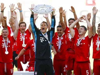 Kapten Bayern Munchen, Manuel Neuer, mengangkat trofi juara Bundesliga usai melawan Wolfsburg di Volkswagen Arena, Sabtu (27/6/2020). Kemenangan itu membuat Bayern kokoh di puncak klasemen sekaligus mengunci gelar juara Bundesliga. (AP/Kai Pfaffenbach)