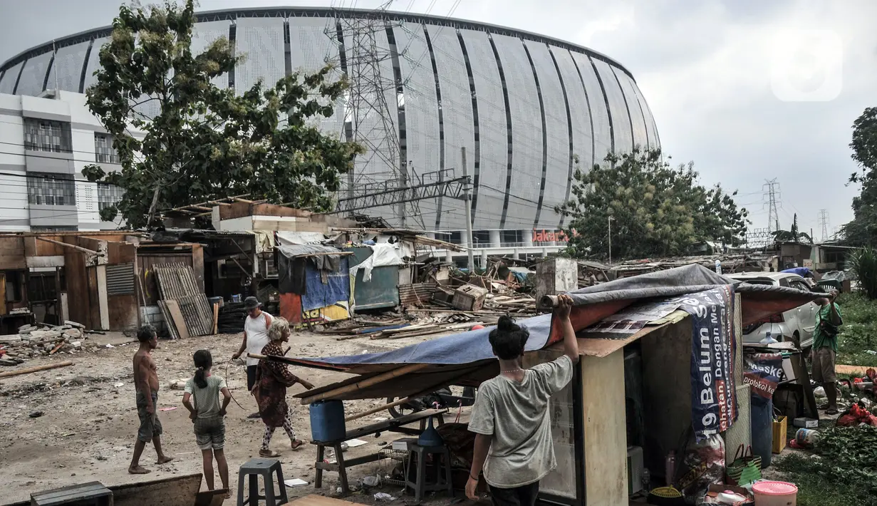 Aktivitas warga pascapenggusuran ratusan bangunan semipermanen di Kampung Bambu, Tanjung Priok, Jakarta Utara, Selasa (11/10/2022). PT KAI membongkar sekitar 254 bangunan semipermanen yang berada di bantaran rel atau dekat Jakarta International Stadium (JIS) guna sterilisasi jalur kereta api dan pembangunan stasiun baru di kawasan tersebut. (merdeka.com/Iqbal S. Nugroho)