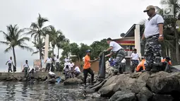 Prajurit Pusat Hidrografi dan Oseanografi TNI AL bersama petugas keamanan Ancol membersihkan sampah di sepanjang Pantai Ancol, Jakarta, Selasa (22/1). Kegiatan tersebut juga untuk memperindah lingkungan di pesisir Ancol. (Merdeka.com/Iqbal S. Nugroho)