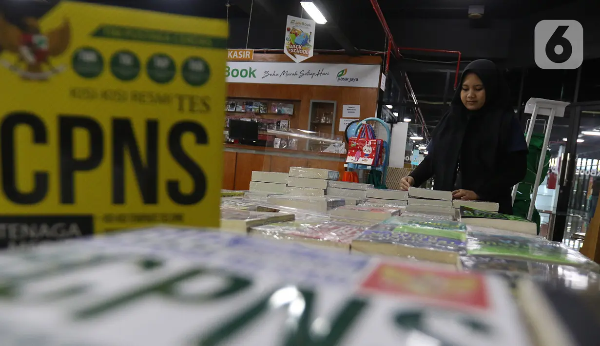 Pekerja merapikan buku di Pasar Kenari, Jakarta, Kamis (28/11/2019). Buku panduan lolos tes yang dijual mulai dari Rp 88.000 hingga Rp 195.000 per eksemplar menjadi barang yang paling dicari dan diminati jelang pelaksanaan tes CPNS. (Liputan6.com/Herman Zakharia)