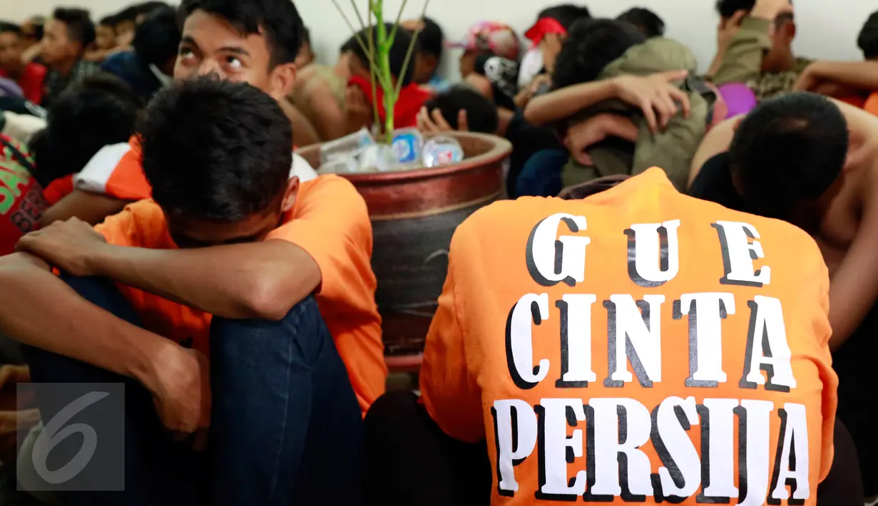 Puluhan pendukung Persija atau The Jakmania ditangkap polisi di Polda Metro Jaya, Jakarta, Minggu (18/10/2015). Para Jakmania itu ditangkap di Ratu Plaza karena menimpuki mobil polisi sampai rusak. (Liputan6.com/Yoppy Renato)