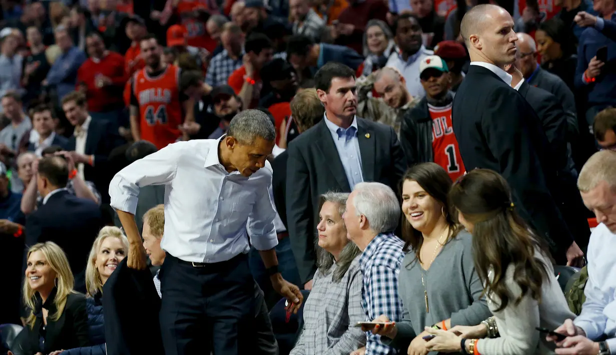 President Amerika Serikat Barack Obama melepas jas saat menyaksikan pembukaan NBA antara  Cleveland Cavaliers melawan Chicago Bulls di Chicago, Selasa(27/10/2015). (REUTERS / Jonathan Ernst)