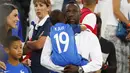 Pemain Prancis, Bacary Sagna menggendong anaknya ditemani istri Ludevin Sagna setalah laga timnya melawan Jerman pada semi-final piala Eropa 2016 di Stade Velodrome, Marseille (7/7/2016). (REUTERS/Christian Hartmann)