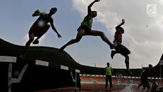 Para pelari melompat saat tampil pada Kejurnas Atletik 2019 nomor 3.000 meter steeplechase senior putra di Stadion Pakansari, Bogor pada Rabu (8/8/2019). Kejurnas Atletik berlangsung dari 3 hingga 7 Agustus. (Bola.com/Peksi Cahyo)