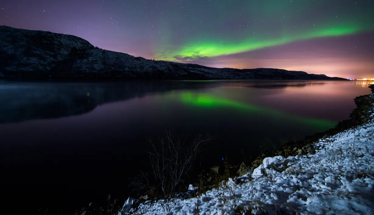 Cahaya berwarna kehijaun tampak menerangi langit malam saat fenomena aurora borealis di dekat kota Kirkenes, Norwegia utara, Kamis (12/11/2015). (AFP PHOTO/Jonathan NACKSTRAND)