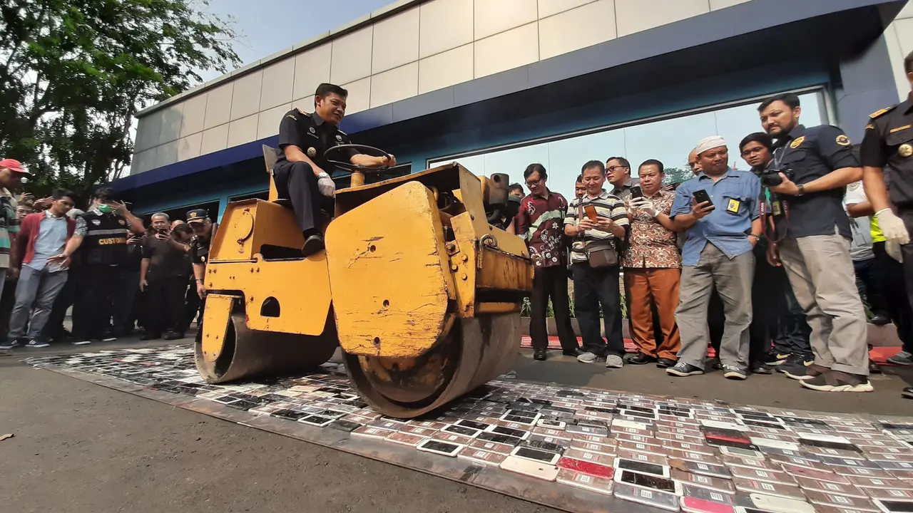 Sebanyak 2.464 unit smartphone senilai Rp 3.5 miliar sitaan Kantor Pelayanan Utama Bea dan Cukai Tipe C Soekarno Hatta, dimusnahkan dengan cara direndam semalaman di air garam dan dilindas alat berat, Selasa (8/10/2019).