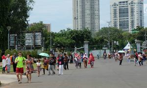 Sejumlah pengunjung berjalan saat sedang liburan di Monumen Nasional (monas), Jakarta, Selasa (25/12). Liburan Natal 2018, banyak warga datang bersama kerabat maupun keluarga memadati Monas. (Liputan6.com/Herman Zakharia)