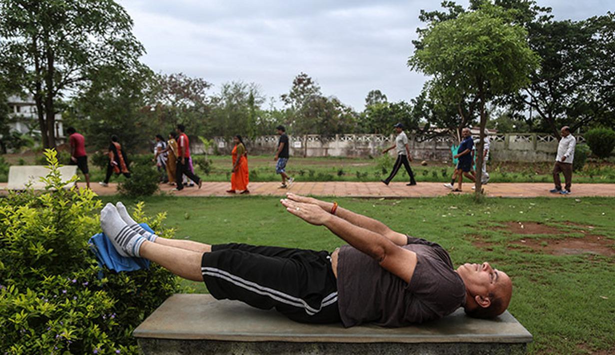Pria India melakukan kegiatan olah tubuh yoga di sebuah taman di kota Mumbai, India. (EPA/Divyakant Solanki))