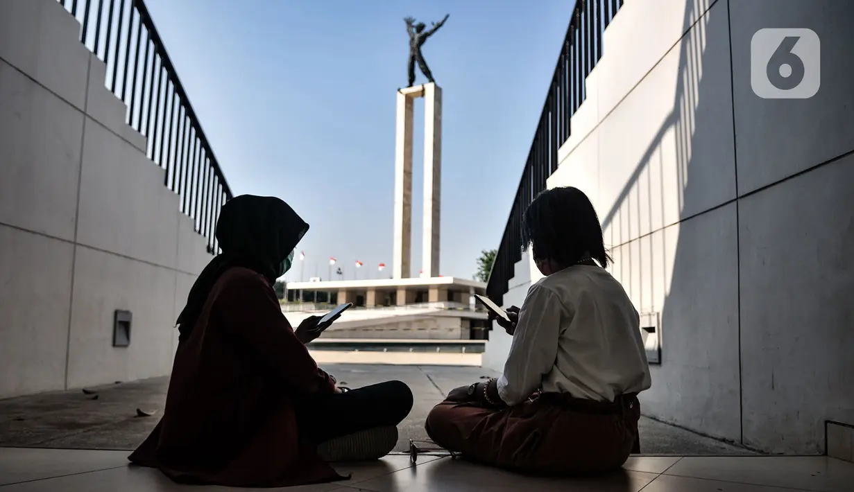 Warga mengakses internet menggunakan jaringan JakWiFi di area Lapangan Banteng, Jakarta, Selasa (8/9/2020). Pemerintah Provinsi DKI Jakarta menargetkan untuk memasang lebih dari 9.000 titik internet gratis di ruang publik. (merdeka.com/Iqbal S. Nugroho)