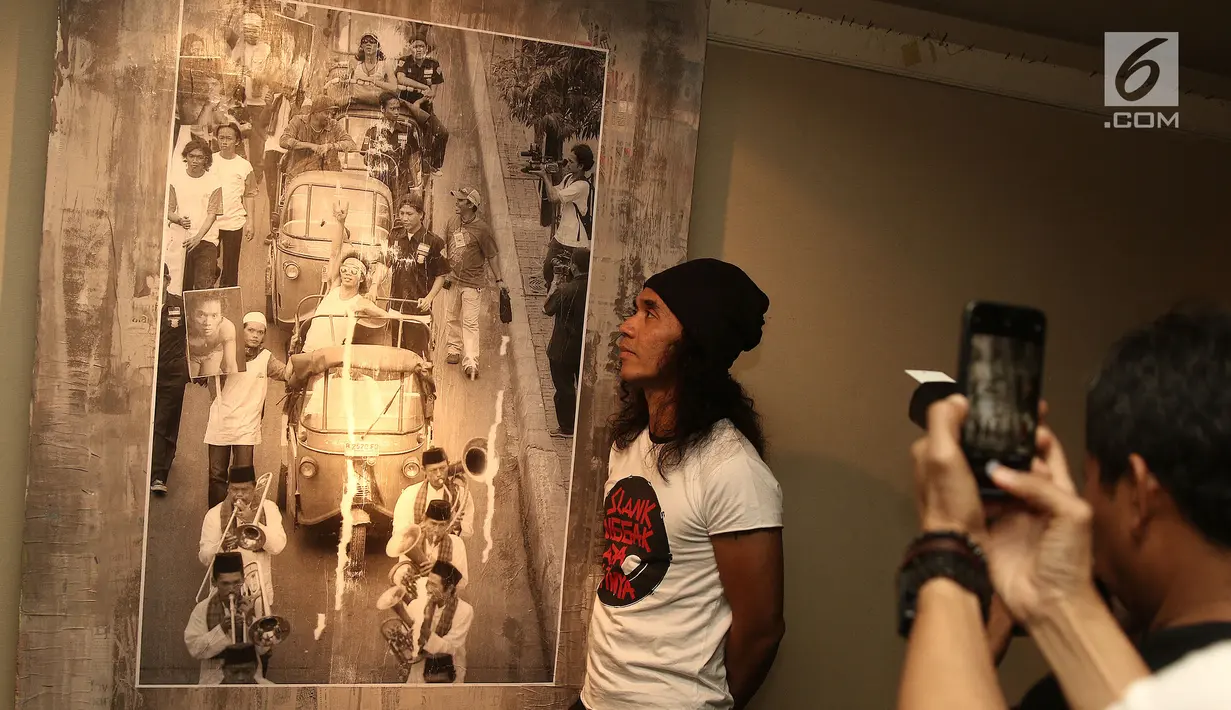 Vokalis Slank, Kaka melihat foto selama pameran foto dan peluncuran buku "Tanpa Batas" karya fotografer Tjandra Moh Amin di Jakarta, Jumat (14/12). Fotografer Tjandra Moh Amin meluncurkan buku Tanpa Batas Slank. (Liputan6.com/Herman Zakharia)