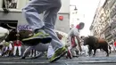 Para peserta berhamburan menyelamatkan diri dari serbuan banteng yang berlari liar di tengah kota saat Festival San Fermin Pamplona, Spanyol, Selasa (7/7/2015). (Reuters/Susana Vera)