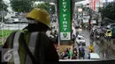 Pekerja proyek mengamati situasi Jalan Ciledug Raya dekat perempatan Seskoal, Jakarta, Jumat (11/11). Hujan deras diringi petir kembali melanda Jakarta mengakibatkan genangan air di beberapa titik. (Liputan6.com/Helmi Fithriansyah)