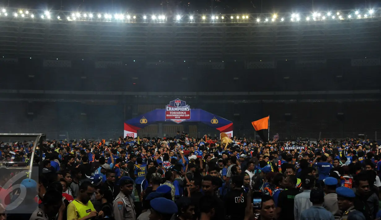 Suporter Arema Cronus memenuhi lapangan saat merayakan kemenangan tim Singo Edan di laga final Piala Bhayangkara 2016 melawan Persib di Stadion GBK Jakarta, Minggu (3/4/2016). Arema Cronus unggul 2-0 atas Persib. (Liputan6.com/Helmi Fithriansyah)