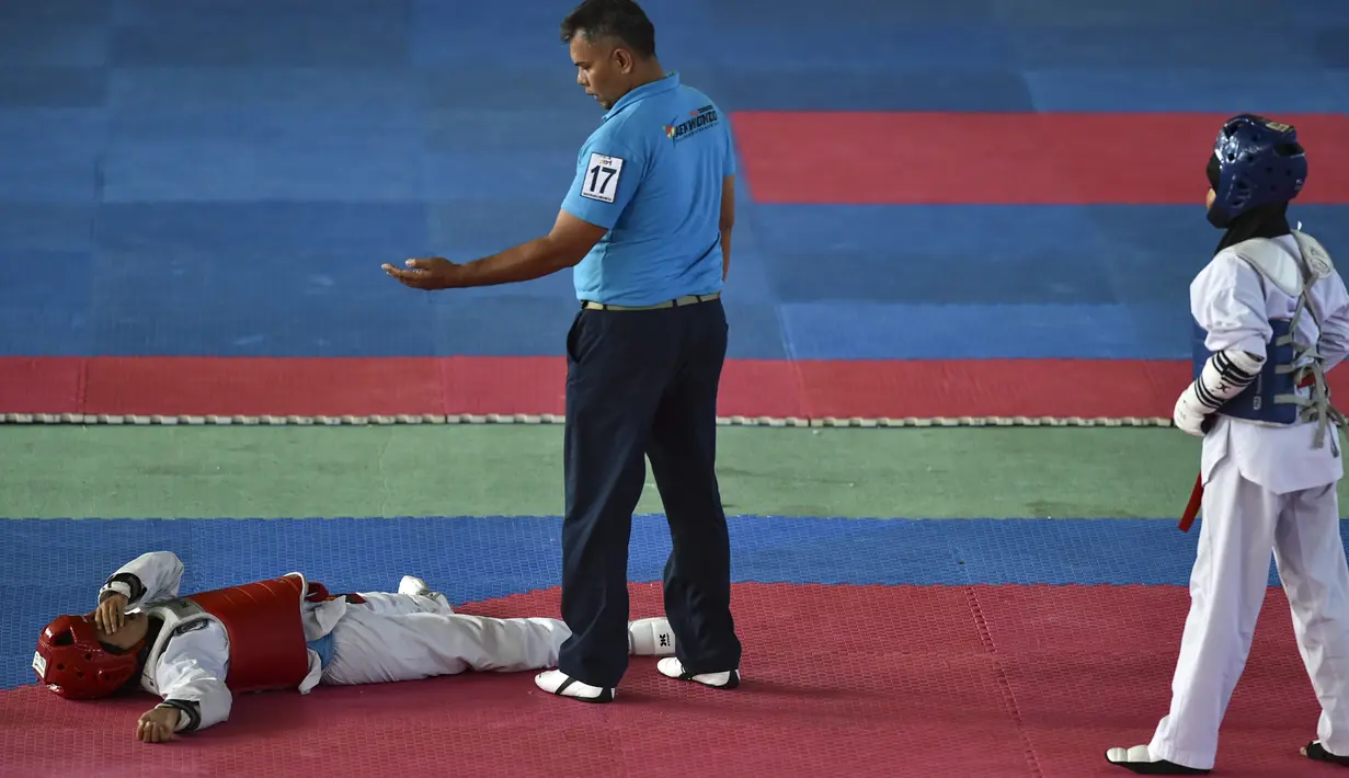 Peserta perempuan terlihat terbaring saat bertanding pada Kejuaraan Terbuka Taekwondo di Banda Aceh (17/7/2019). Kejuaraan Taekwondo ini berlangsung 12-18 Juli 2019. (AFP Photo/Chaideer Mahyuddin)
