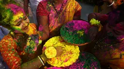Warga bermain dengan tepung berwarna-warni untuk merayakan Festival Holi di Kolkata, India, Kamis (1/3). Festival ini juga mendatangi datangnya musim semi. (Dibyangshu SARKAR/AFP)