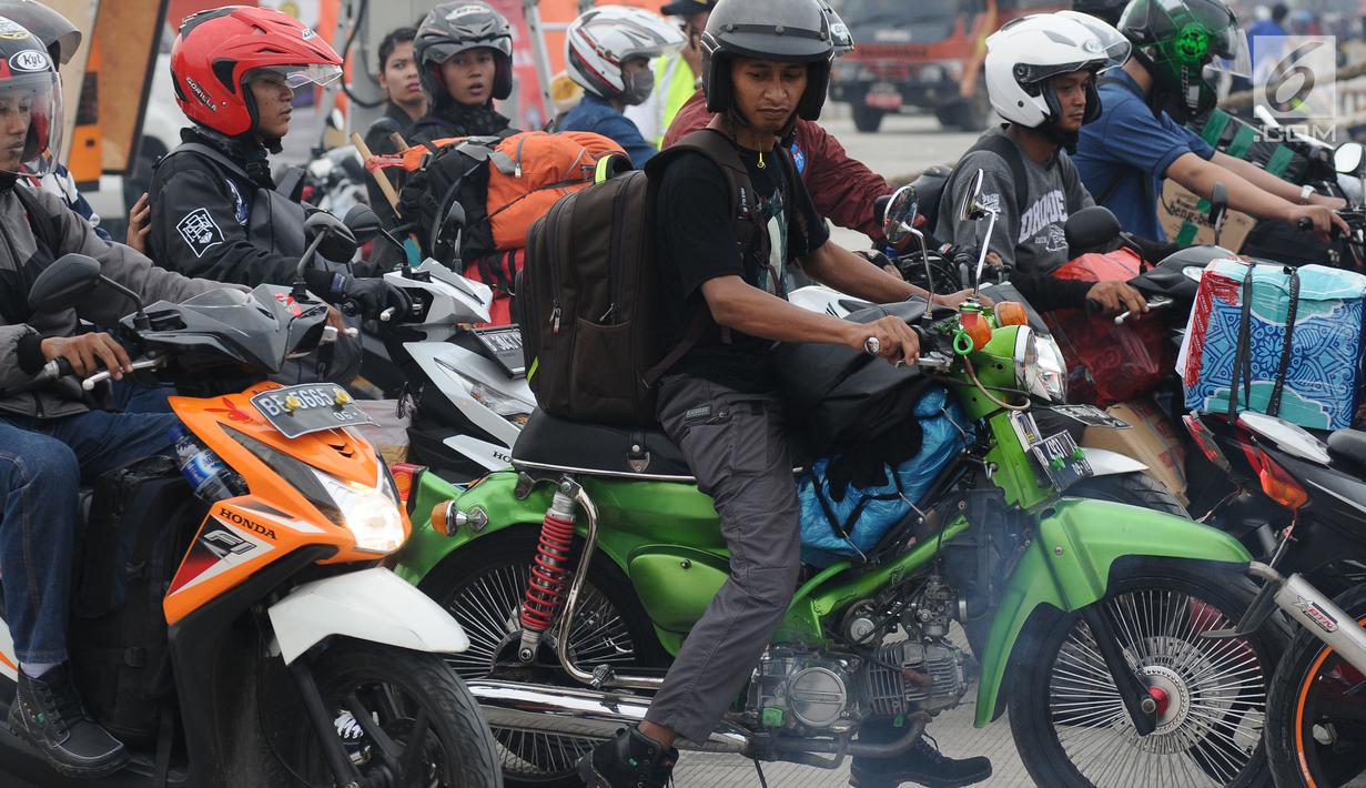 Pemudik menggunakan motor Honda keluaran tahun 70 an saat antri masuk kapal penyeberangan di Pelabuhan Merak, Banten, Jumat (23/6). H-2 Lebaran 2017, ribuan pemudik bermotor memadati dermaga 6 Pelabuhan Banten. (Liputan6.com/Helmi Fithriansyah)