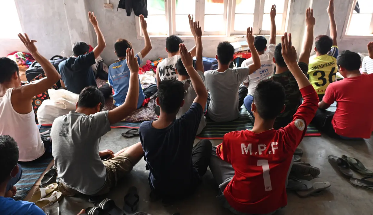 Polisi Myanmar, yang melarikan diri dari Myanmar dan menyeberang secara ilegal ke India, melakukan penghormatan tiga jari di tempat penampungan sementara di lokasi yang dirahasiakan di negara bagian Mizoram di timur laut India (13/3/2021).  (AFP/Sajjad Hussain)