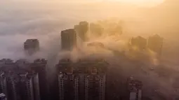 Foto udara ini menunjukkan bangunan yang diselimuti kabut pagi di Bijie, provinsi Guizhou barat daya China (18/11/2021).  Pada 10 November 2011, bekas Prefektur Bijie diubah menjadi kota setingkat prefektur, dan bekas kota tingkat kabupaten Bijie diubah namanya menjadi Distrik Qixingguan. (AFP/STR)