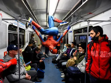 Penari underground yang mengenakan kostum Spiderman tampil di kereta bawah tanah Saint Petersburg, Rusia pada 21 Mei 2021. Kemunculan dua penari berkostum Spiderman tersebut membuat sejumlah penumpang yang berada di dalam subway kaget dan terhibur. (Olga MALTSEVA / AFP)