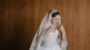 Enzy Storia juga tampil dengan gaun pernikahan warna putih model bustier lengkap bawahan satin dan veil berbordir dari Monica Ivena. [@enzystoria]