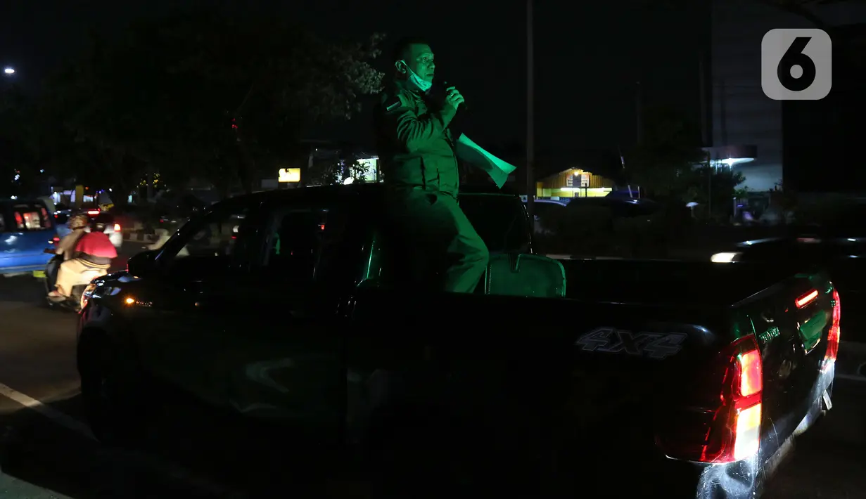 Petugas melakukan sosialisasi aturan jam malam di sepanjang Jalan Margonda, Depok, Senin (31/8/2020). Sosialisasi aturan jam malam dilakukan selama 3 hari di kawasan Depok yang diberlakukan mulai malam hari ini guna meminimalisir penyebaran covid-19. (Liputan6.com/Herman Zakharia)