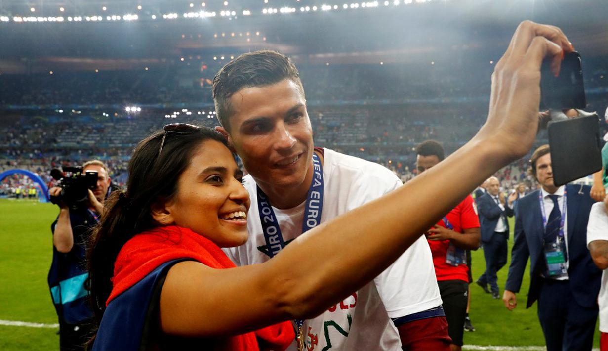 Cristiano Ronaldo berfoto dengan seorang fan seusai menjuarai Piala Eropa 2016 di Stade de France, Saint-Denis, Senin (11/7/2016) dini hari WIB. (Reuters/Michael Dalder)