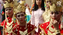 Sejumlah wanita mengenakan pakaian adat saat melakukan karnaval di jalan Pintu 1 Senayan, Jakarta, Minggu (24/9). Karnaval tersebut dilakukan dalam rangka HUT Gelora Bungkarno yang ke-55. (Liputan6.com/Angga Yuniar)