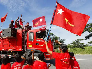 Pendukung partai National League for Democracy (NLD) pimpinan Aung San Suu Kyi mengibarkan bendera partai dan bersorak-sorai dari truk saat kampanye pemilihan umum bulan depan di Naypyitaw, Myanmar, Rabu (21/10/2020). (AP Photo/Aung Shine Oo)