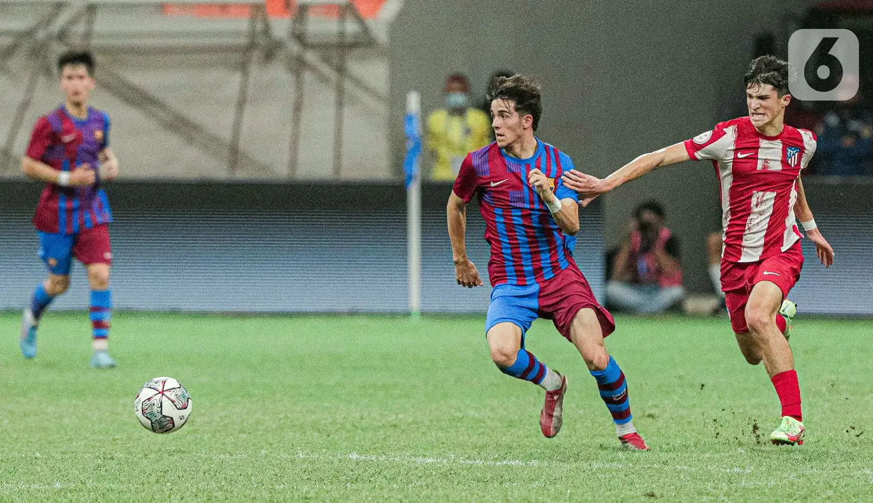 Pemain Barcelona U-18 (tengah) berebut bola dengan pemain Altetico Madrid U-18 pada pertandingan International Youth Championship (IYC) 2021 di Jakarta International Stadium (JIS), Jakarta, Selasa (19/4/2022). Barcelona U-18 menang 1-0. (Liputan6.com/Faizal Fanani)