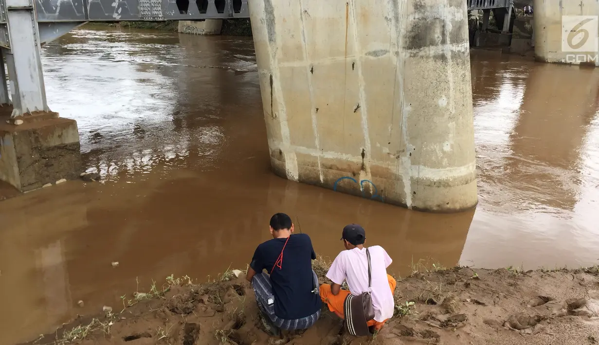 Dua orang warga menunggu pancingnya dimakan oleh ikan di Sungai Ciliwung, Rawajati,Jakarta, Selasa (6/2). (Liputan6.com/Immanuel Antonius)