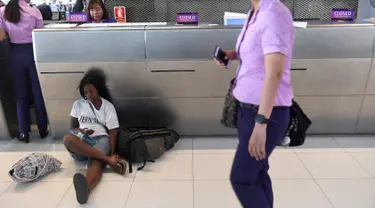 Penumpang beristirahat di area check-in di Bandara Internasional Suvarnabhumi di Bangkok (28/2). Puluhan penerbangan menuju Eropa dibatalkan setelah Pakistan menutup wilayah udaranya karena ketegangan dengan India meningkat. (AFP Photo/Lillian Suwnrumpha)