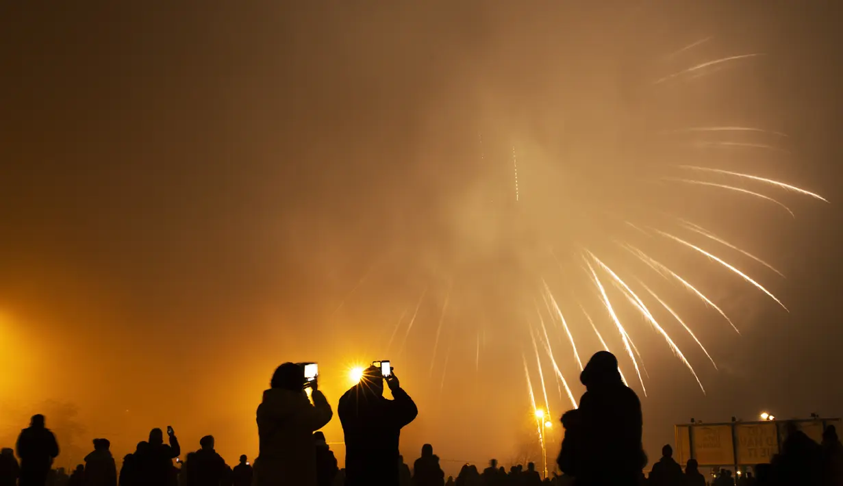 Kembang api meledak pada malam berkabut untuk menandai awal Tahun Baru di Brussels, Belgia, Rabu (1/1/2020). (AP Photo/Francisco Seco)