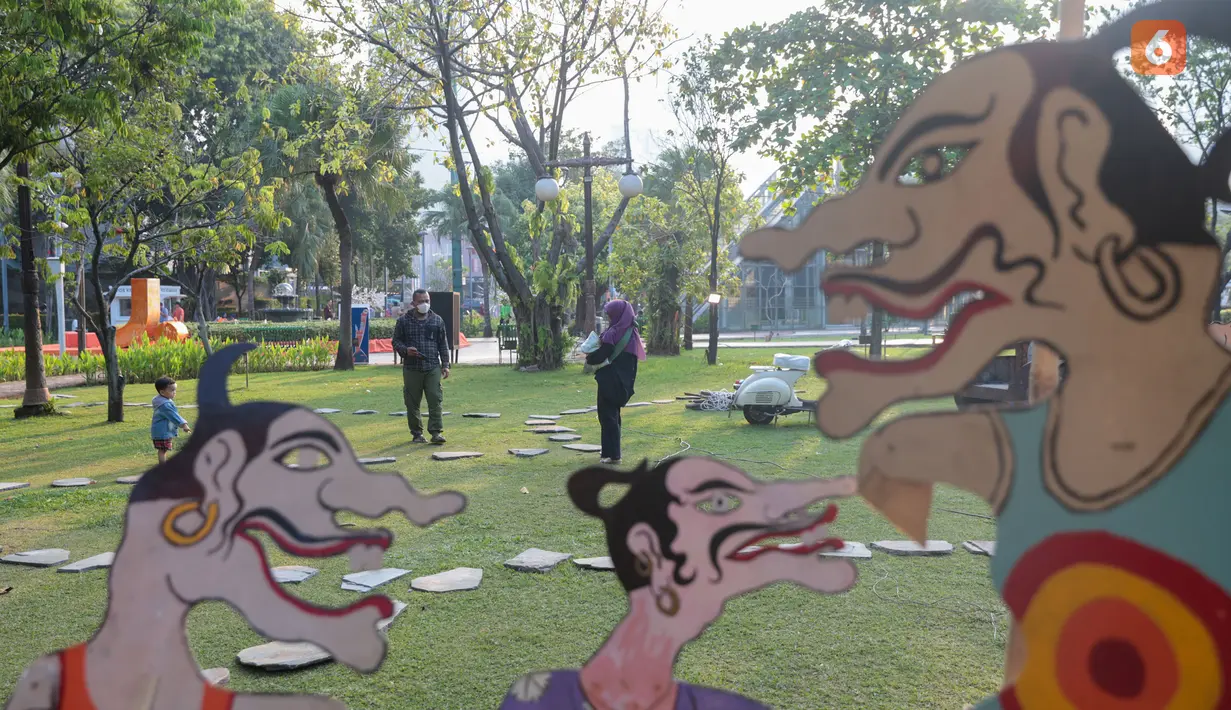 Pengunjung mengamati karya dalam pameran seni rupa kontemporer luar ruang Jakarta Provoke! di Taman Menteng, Jakarta Pusat, Jumat (17/7/2026). Pameran gratis yang berlangsung hingga 26 Juli 2026 ini menghadirkan 25 karya dari 25 seniman dan kolektif tentang dinamika kehidupan Jakarta. (KLY/Budy Santoso)